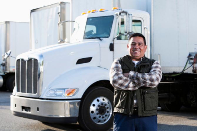 a man with arms crossed in front of a truck