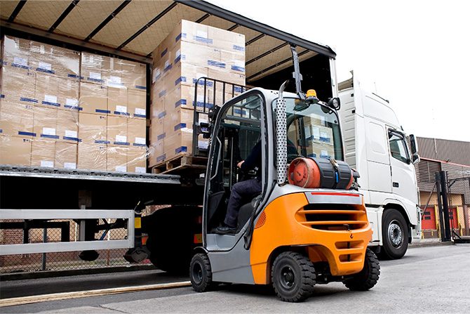 Forklifts loading boxes in trailer