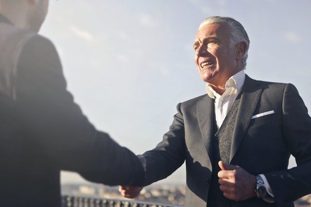 A professional shaking hands with a new client, showing one of the benefits of being able to reduce sea freight transit time