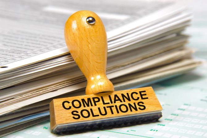 Sello de “Compliance Solutions” sobre documentos, representando el cumplimiento regulatorio en la industria farmacéutica.
