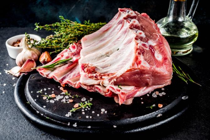 Raw pork ribs on a black tray, representing one of the top exports in the perishable foods list from the U.S. to Mexico