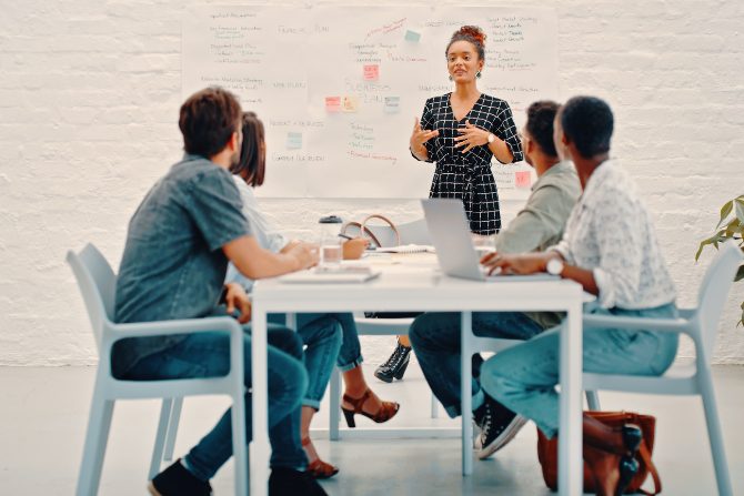 group meeting with a whiteboard on the background.